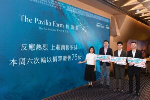 Group of four adults in business attire posing with signs in front of a blue backdrop with The Pavilia Farm branding and Chinese text event photo