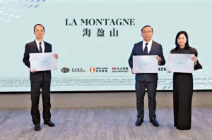 Three professionally dressed individuals stand side by side each holding a certificate in front of a light blue backdrop with the text LA MONTAGNE and logos below