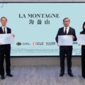 Three professionals in suits hold certificates while standing in front of a light blue backdrop that reads LA MONTAGNE with logos below