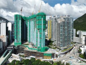 2024年6月港島南岸 | 利嘉閣地產有限公司 High rise construction site with green safety netting and multiple cranes against a cloudy sky
