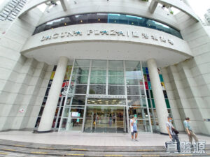 Entrance to Laguna Plaza shopping mall with curved concrete facade and tall glass doors