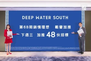 Two people stand on either side of a large blue banner reading DEEP WATER SOUTH with Chinese text beneath it posing for a photo