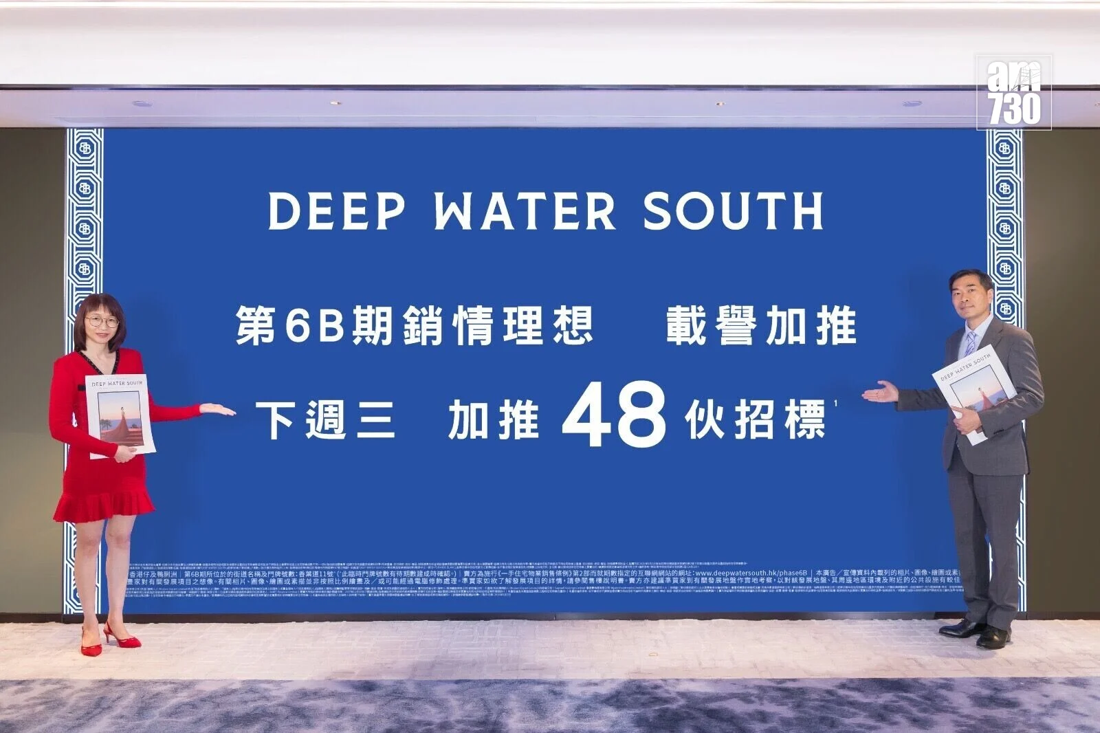 Two people stand on either side of a large blue banner reading 'DEEP WATER SOUTH' with Chinese text beneath it, posing for a photo.