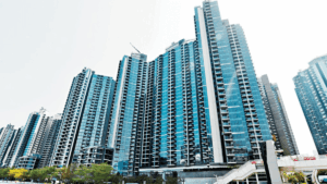 DOUBLECOASTIII | 利嘉閣地產有限公司 Cluster of tall blue glass residential towers in a modern city skyline with a pedestrian overpass in the foreground