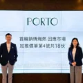 Two professionals stand in front of a large screen that reads PORTO with Chinese text logo top right posing for a presentation photo