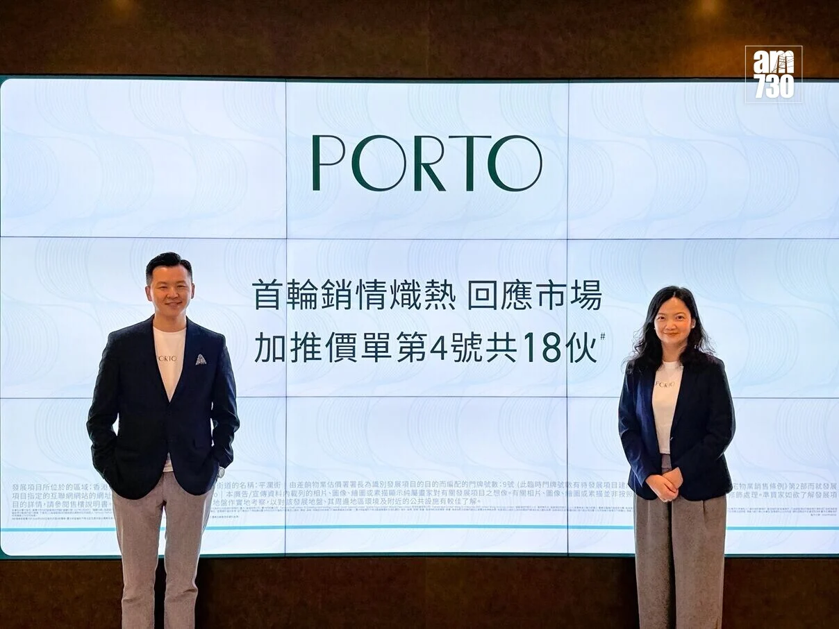 Two professionals stand in front of a large screen that reads PORTO with Chinese text, logo top-right, posing for a presentation photo.