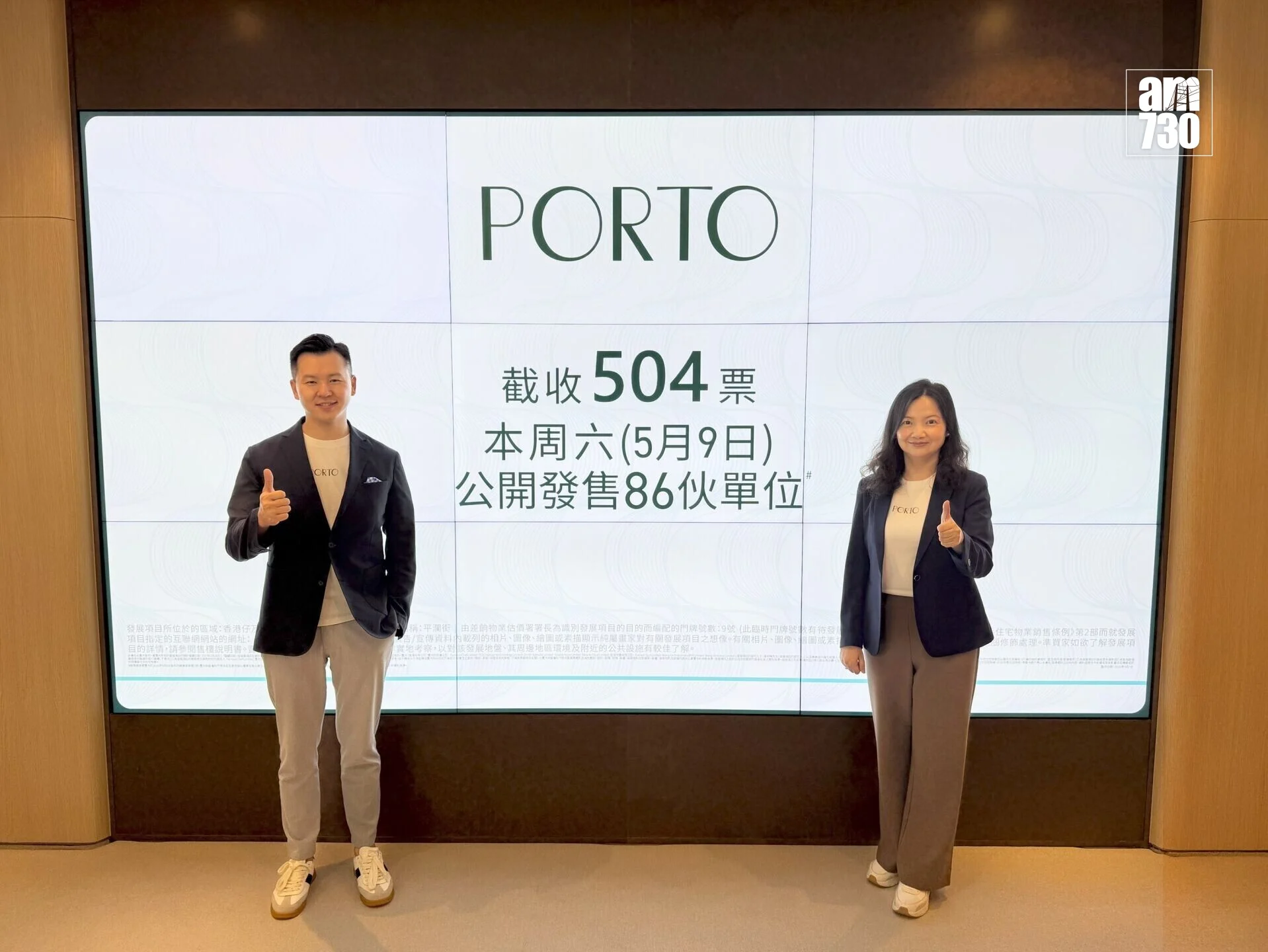 Two presenters stand in front of a large screen displaying PORTO branding and Chinese text, giving thumbs up in a corporate promotional setting.