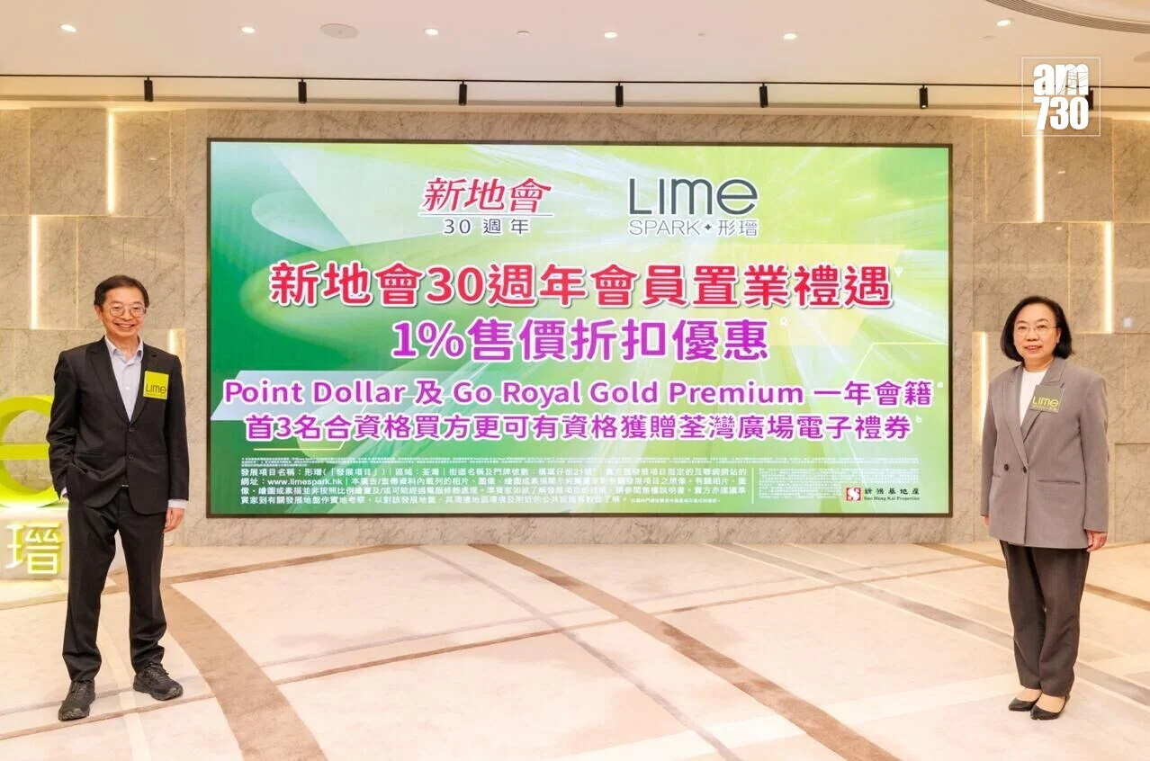 Two well-dressed individuals stand on either side of a large, colorful promotional banner for a 30th anniversary event by Lime, set in a bright lobby.