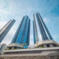 Three blue glass skyscrapers rise into the sky photographed from street level