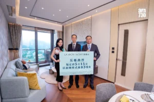 Three people in a modern living room hold a large blue poster with Chinese text
