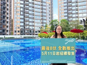 Woman stands at a blue tiled poolside holding a teal promotional sign with Chinese text tall apartment buildings in the background and red umbrellas nearby